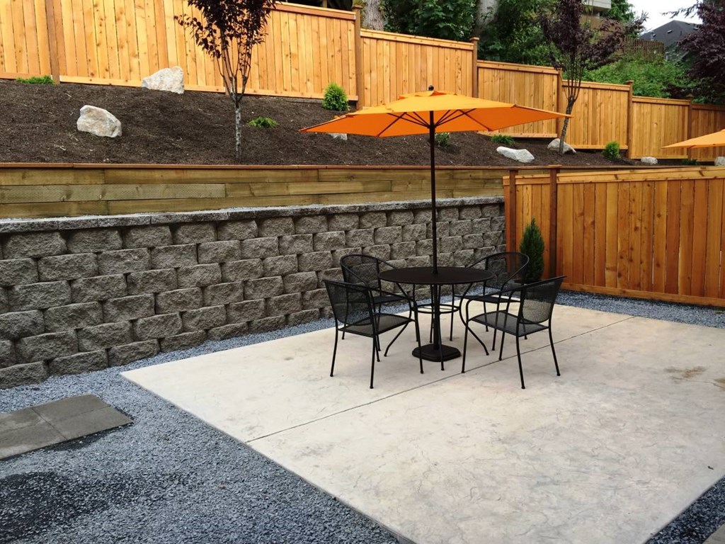 a patio with a table and chairs and an umbrella