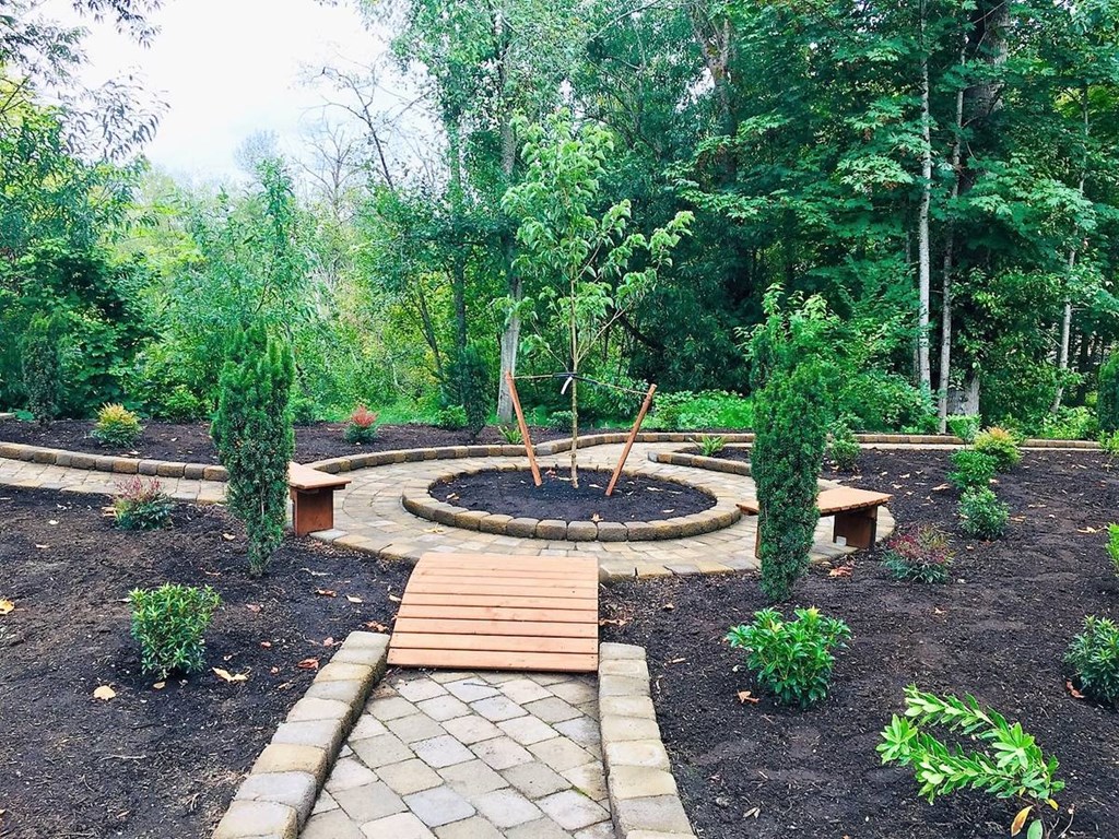 a garden with a fire pit and benches