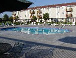 an empty swimming pool in front of an apartment building
