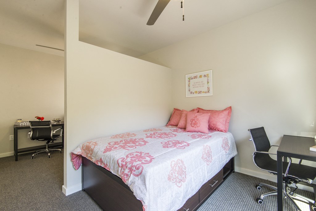 a bedroom with a bed and a desk with a chair