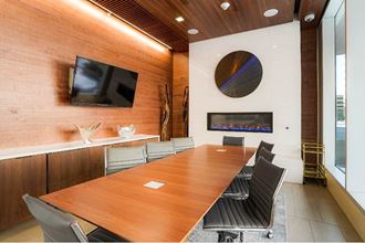 a conference room with a long table and a television