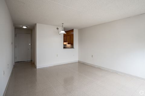 the living room and dining room of an empty house with white walls and tile floors