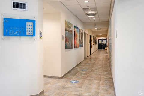 a hallway with paintings on the walls and a blue sign on the wall
