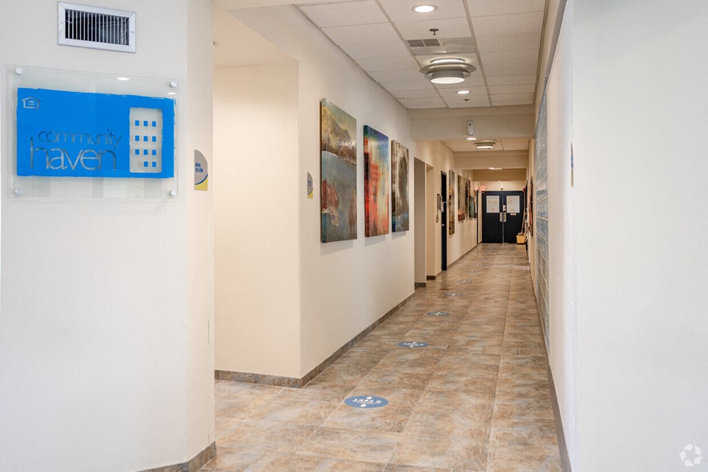 a hallway with paintings on the walls and a blue sign on the wall