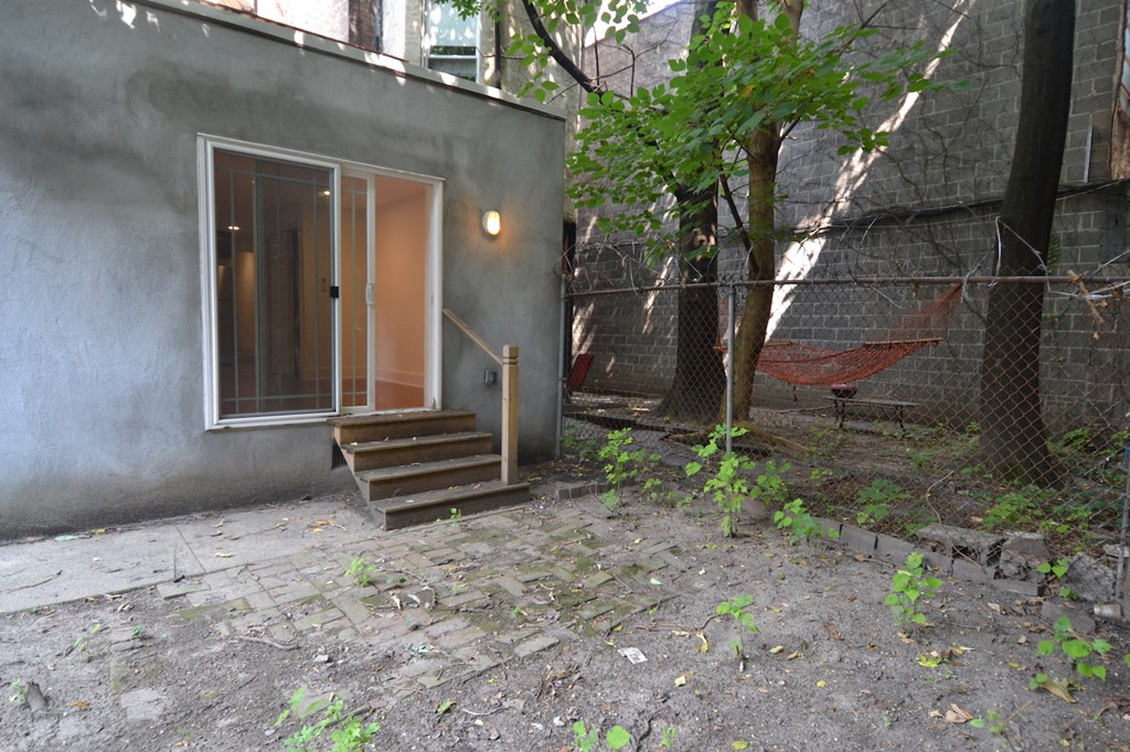the back yard of a house with a porch and a swing