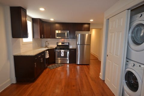 a kitchen with stainless steel appliances and a washer and dryer in it