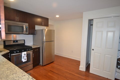 a kitchen with stainless steel appliances and a door to the refrigerator