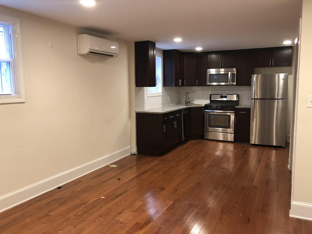 a kitchen with wooden floors and stainless steel appliances