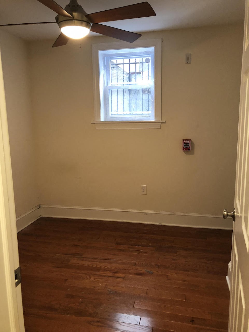 a empty room with a ceiling fan and a window