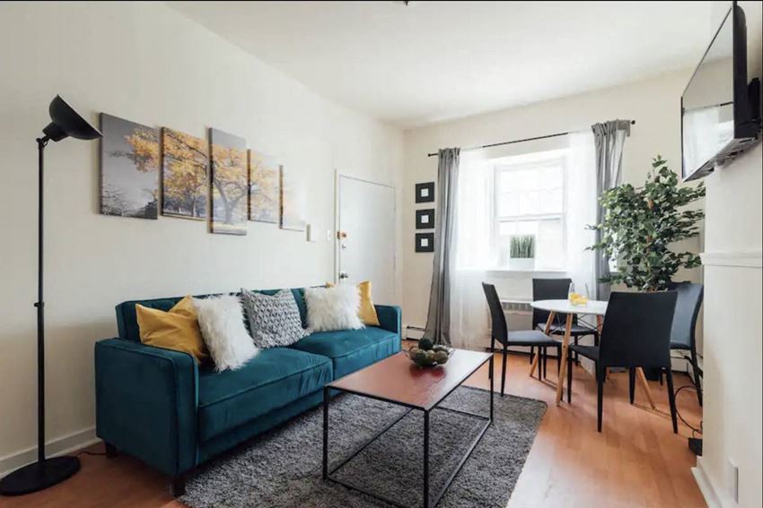 a living room with a blue couch and a dining room table
