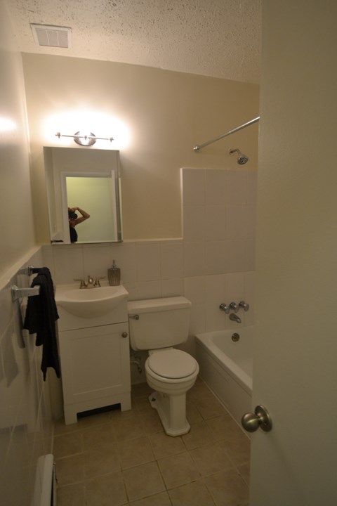 a small bathroom with a toilet sink and tub and a mirror