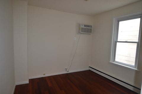 an empty room with a air conditioner and a window