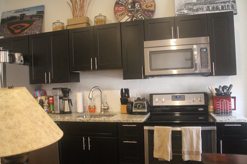 a kitchen with black cabinets and stainless steel appliances