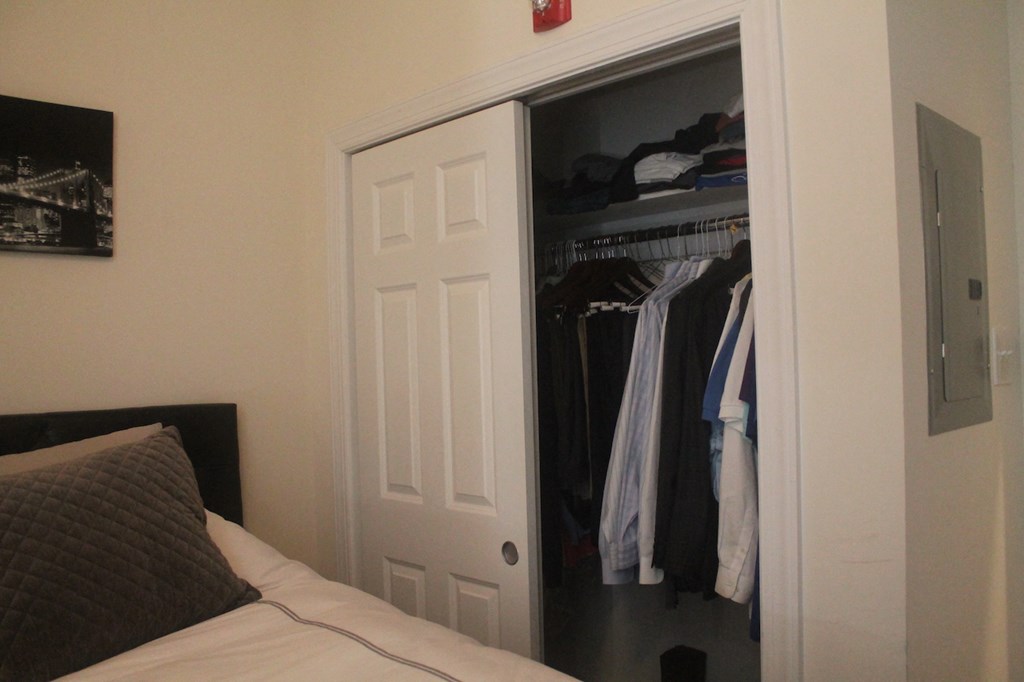 a closet with a white door and a bed in front of it