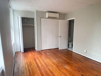 an empty living room with wood floors and a closet