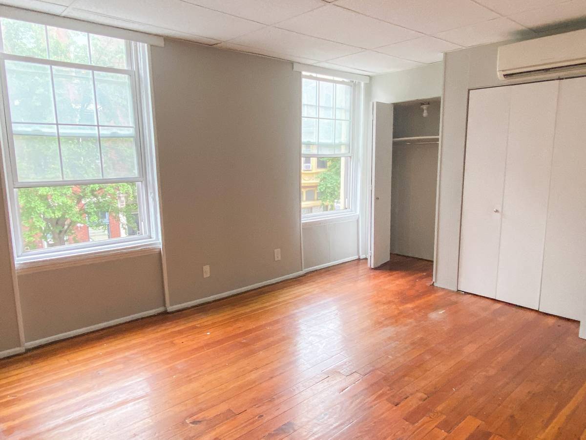 a living room with a hard wood floor and a closet