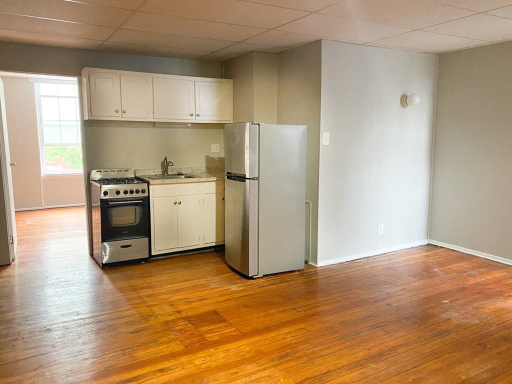 an empty kitchen with a refrigerator and a stove