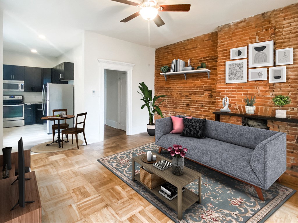 a living room with a couch and a table in front of a brick wall