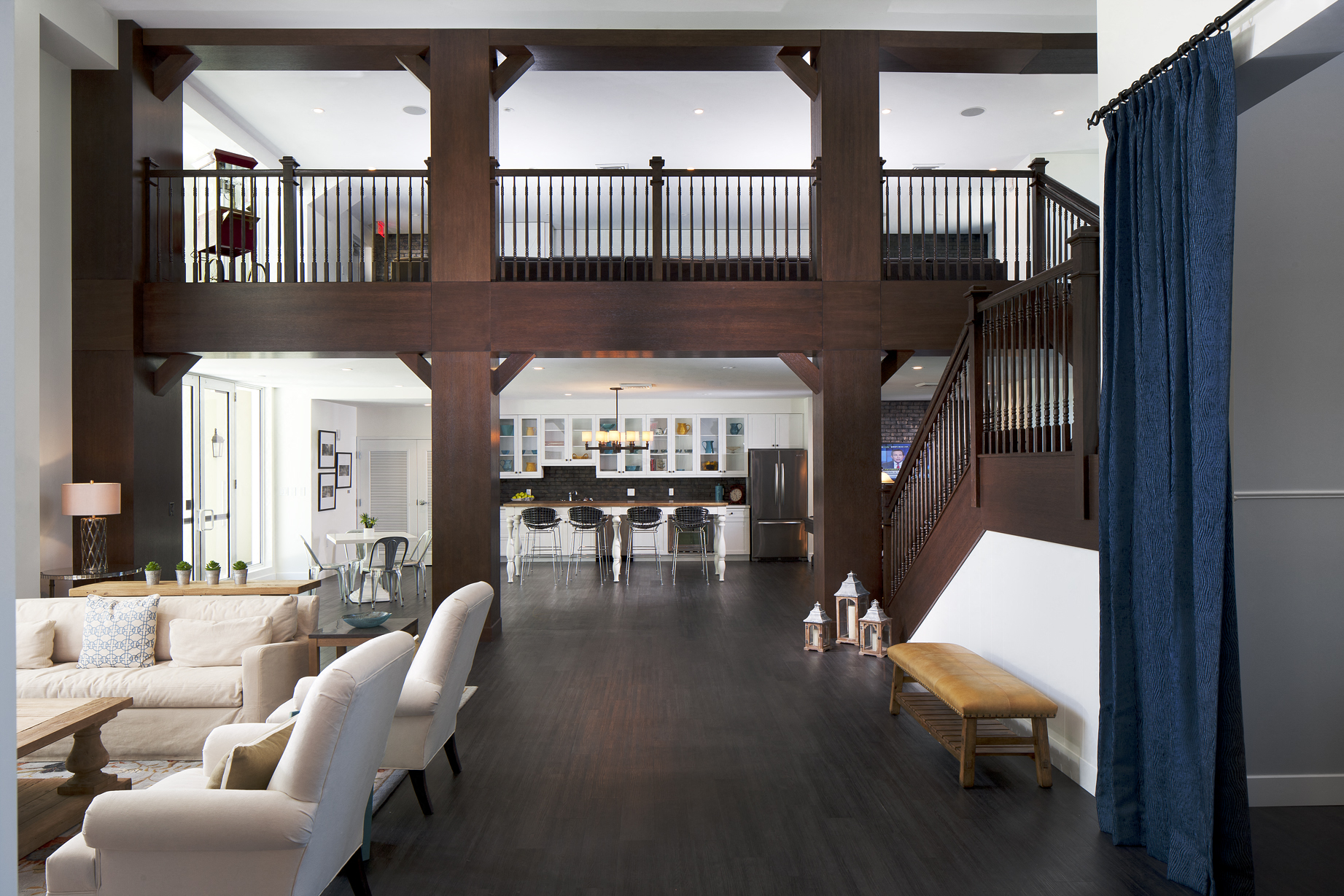 a living room with white furniture and a staircase