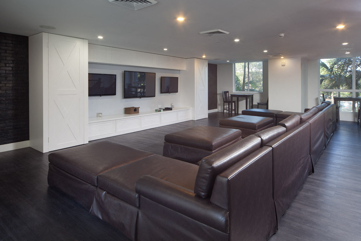 a large living room with leather couches and a television