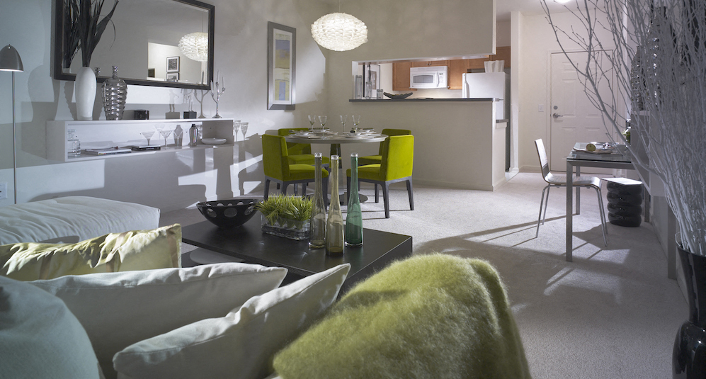 a living room with couches and a table and a kitchen