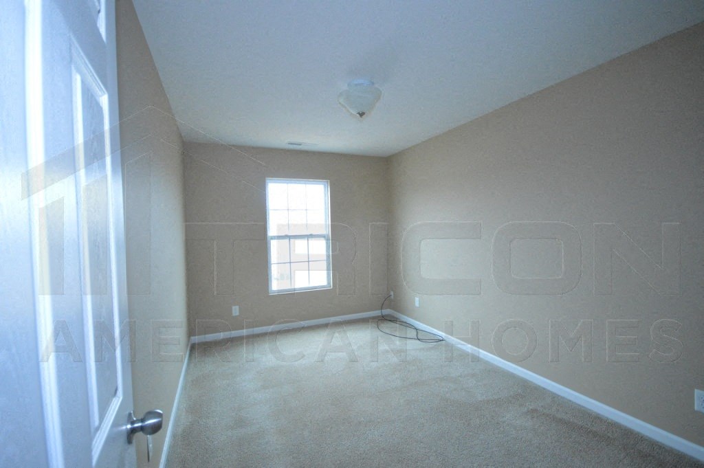 an empty room with a window and a door