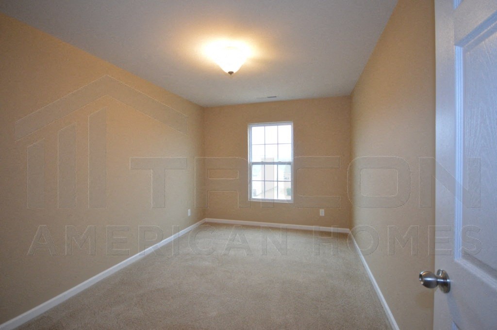 an empty room with a window and a white door