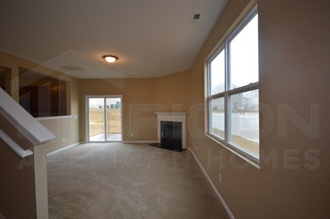 an empty living room with a fireplace and a large window