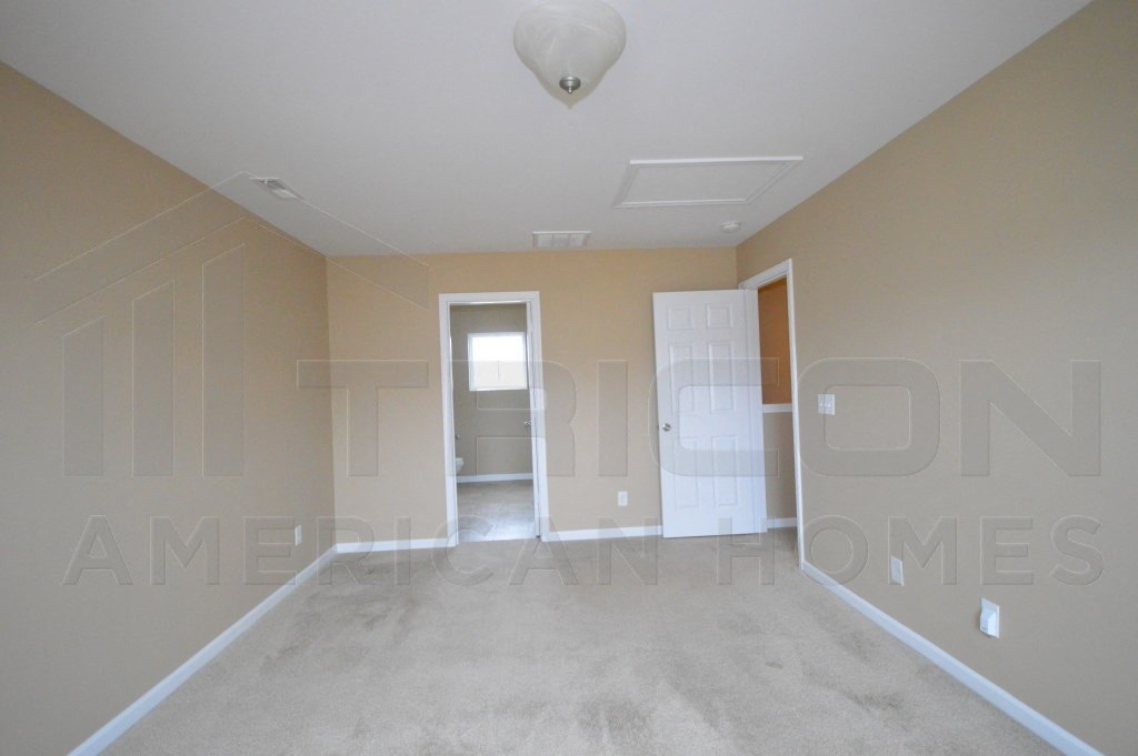 an empty living room with beige walls and a concrete floor