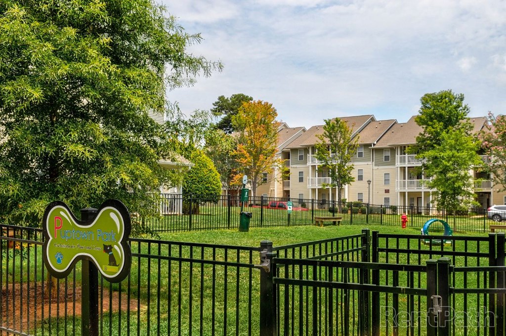 a park with a fence and apartment buildings