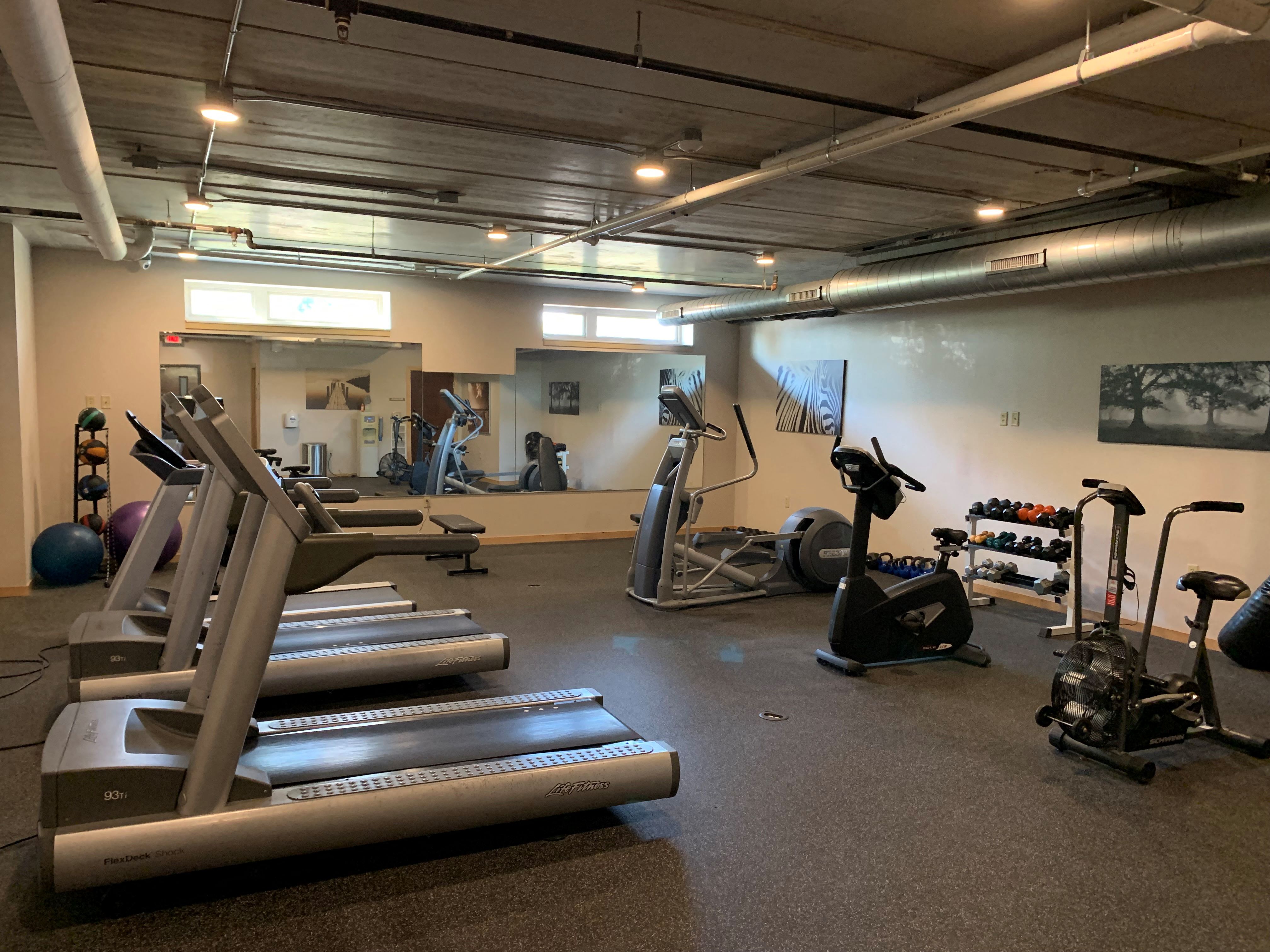 a gym with cardio equipment and weights in a building