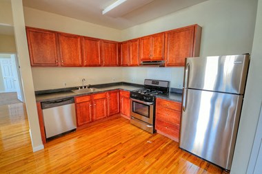 Kitchen with stainless steel appliances, wooden cabinets and hardwood floors