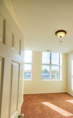 Bedroom with carpeted floor and two large windows - Photo Gallery 5