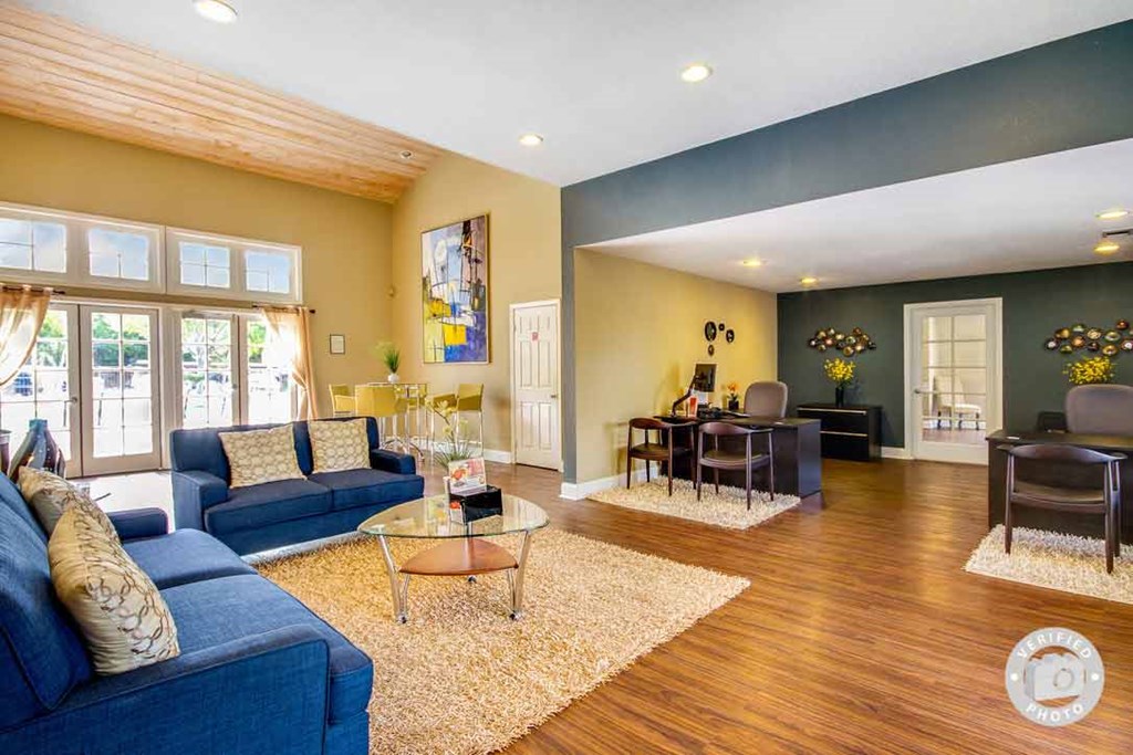 a living room with blue couches and a glass coffee table