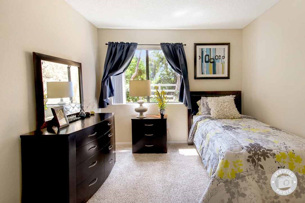 a bedroom with a bed and a dresser and a window