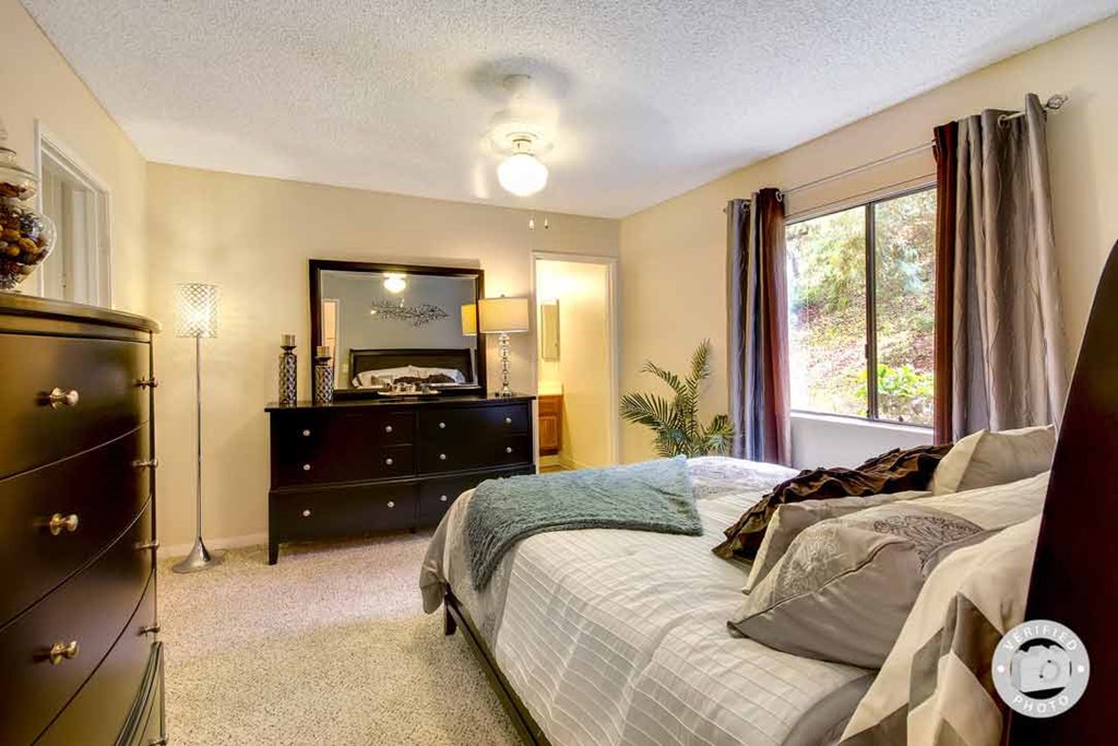 a bedroom with a bed and a dresser with a mirror