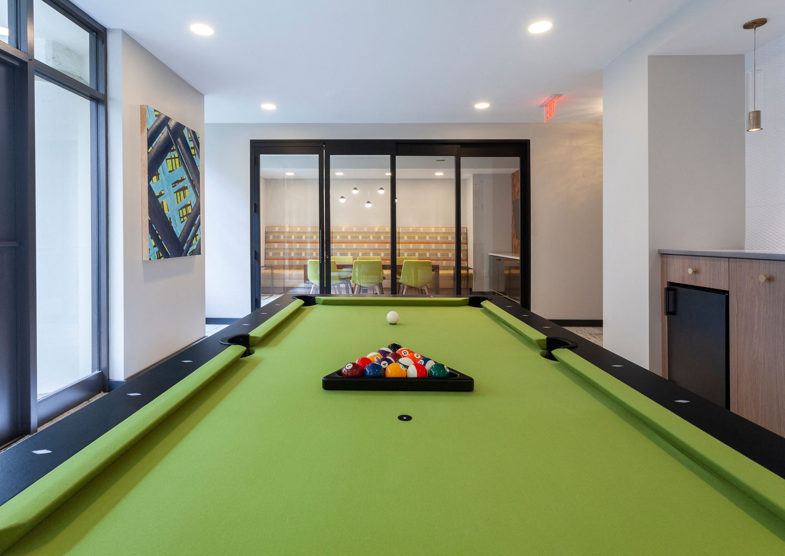 a snooker table with balls on it in a room with a window