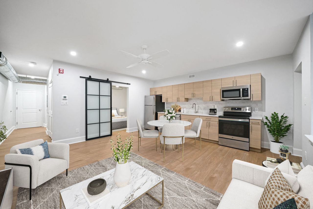 a living room and kitchen with a table and chairs