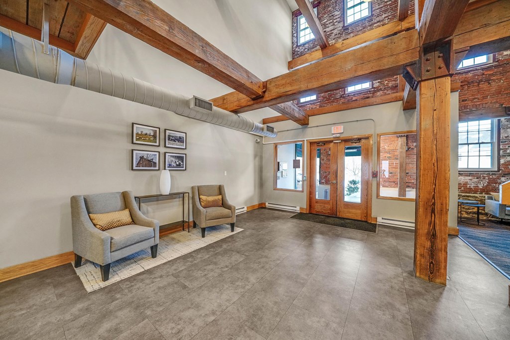 the lobby of a building with two chairs and a table