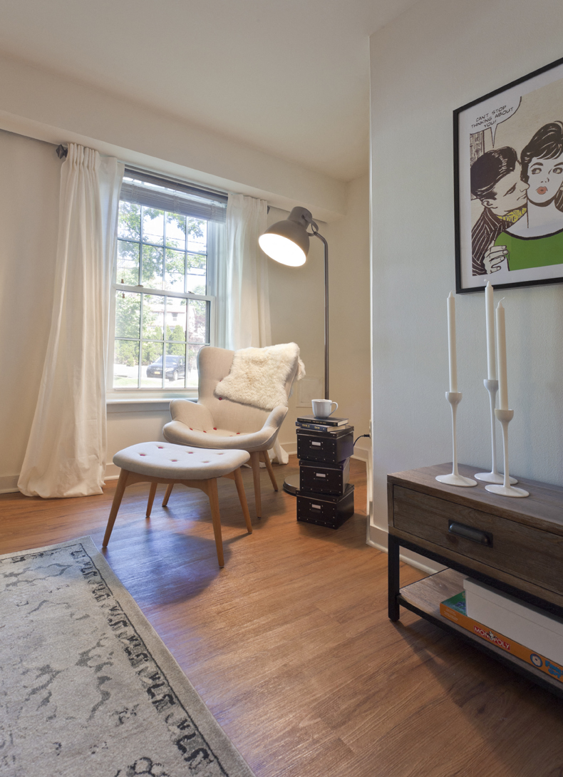 a living room with a chair and a table and a window