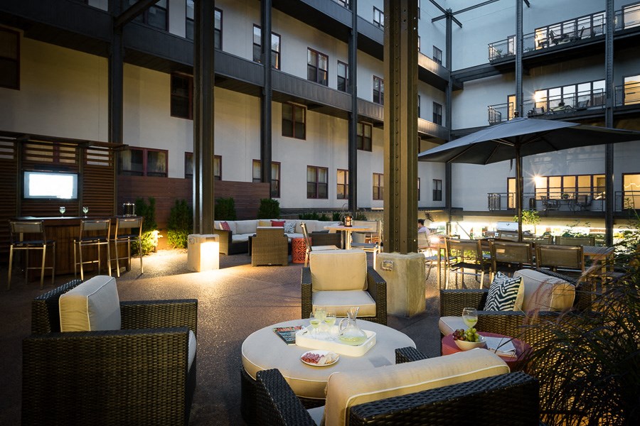 a patio with tables and chairs and a building in the background