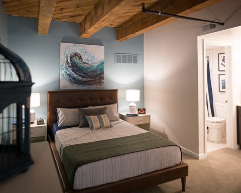 a bedroom with a bed and a painting on the wall