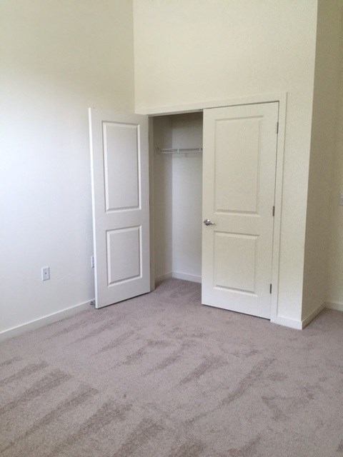 an empty room with two doors and a closet