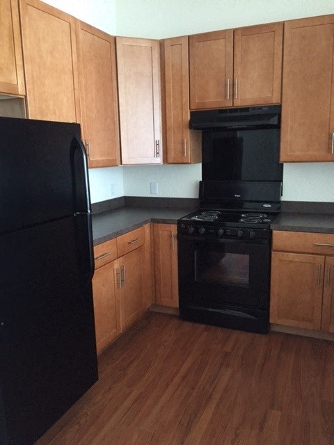 a kitchen with black appliances and wooden cabinets