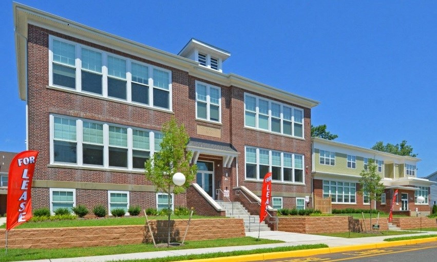 the front of a brick building with red signs in front