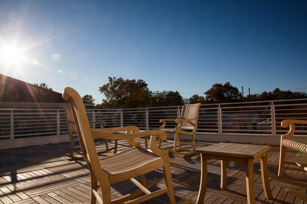 a deck with chairs and a table on a balcony
