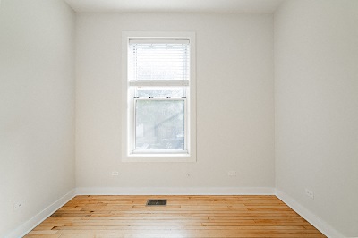 a empty room with a window and a wooden floor