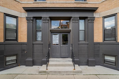 the front of a building with gray doors and windows