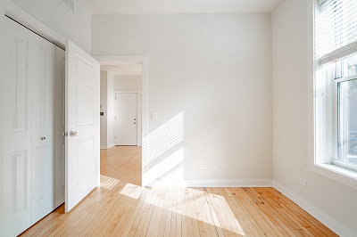 an empty room with white walls and a wood floor