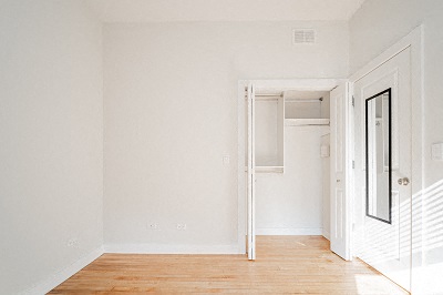 an empty room with white walls and a wood floor